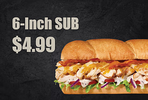 A 6-inch sub sandwich filled with chicken, lettuce, tomato, cheese, and drizzled with ranch dressing on a toasted wheat bun